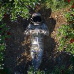 Astronaut inmitten einer Blumenoase, eine ruhige 3D-Szene, der Astronaut liegt entspannt auf dem Boden.