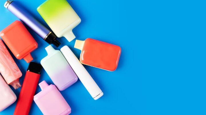 Verschiedene bunte Einweg-E-Zigaretten inklusive Modelle wie die Elf Bar 800 auf blauem Hintergrund